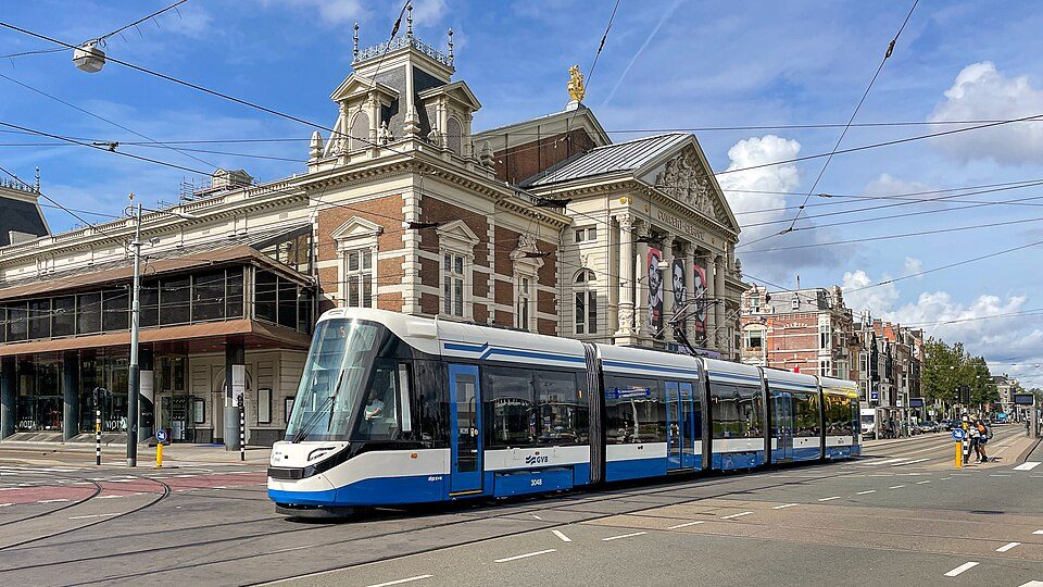 Nuevo tranvía 15G de la línea 5 pasando junto al Concertgebouw en el Museumplein de Ámsterdam, bajo un cielo azul