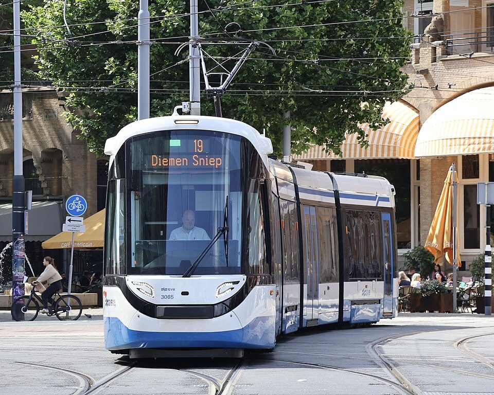 Blue and white GVB tram on line 19 at Leidseplein in Amsterdam, with café terraces in the background