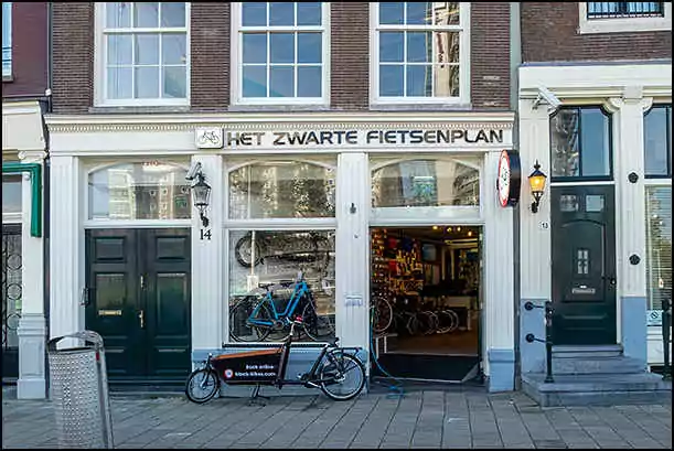 black bikes storefront amsterdam central station